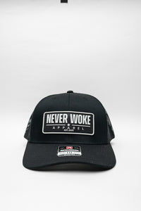 Black cap with 'Never Woke Apparel' logo on a black background with white boarder and letters