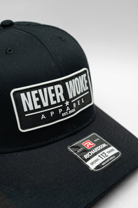 Black cap with 'Never Woke Apparel' logo on a black background with white boarder and letters